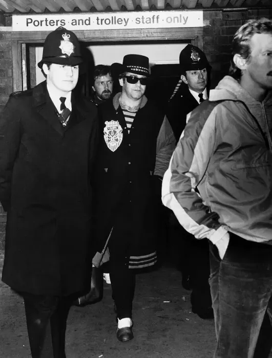 Framed Print : Elton John, pictured at Heathrow Airport, surrounded by police after getting off Framed Print : Elton John, pictured at Heathrow Airport, surrounded by police after getting off