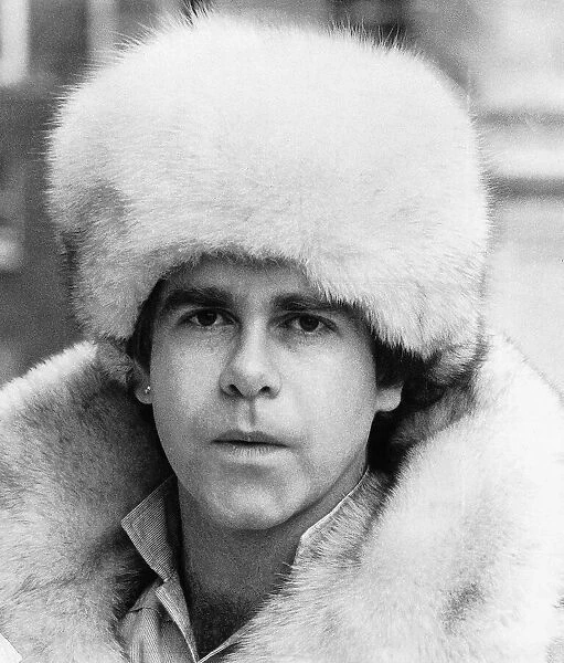 Elton John pop singer wearing a white fur hat and coat. 1978