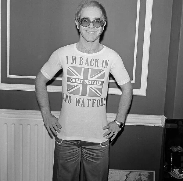 Elton John returns from America to announce that he is back in Britain for good