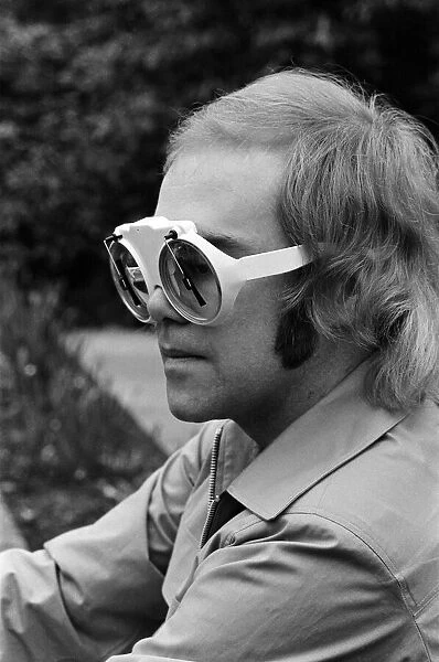 Elton John, singer, pictured at home in Virginia Water. He is wearing glasses which have