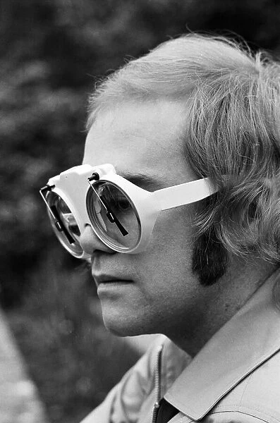 Elton John, singer, pictured at home in Virginia Water. He is wearing glasses which have