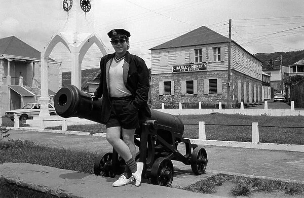 Elton John Singer Songwriter standing beside a cannon on the West Indies Island of