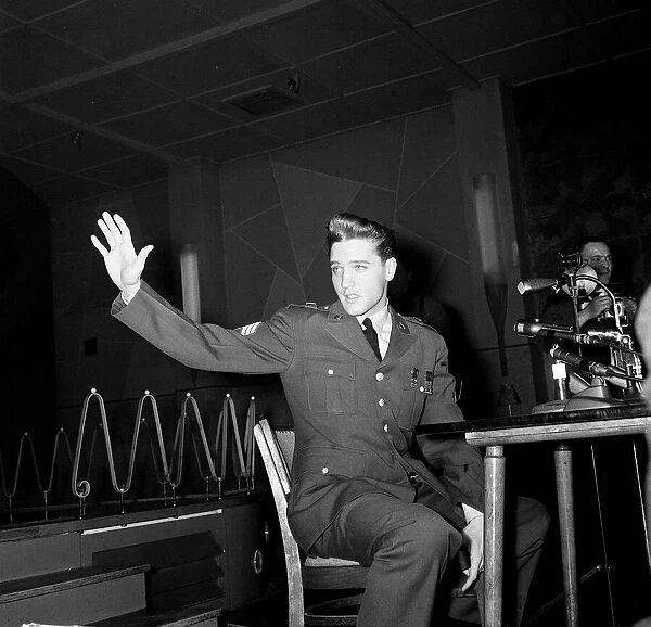 Elvis Presley wearing army uniform waves at press conference in Germany, March 1960