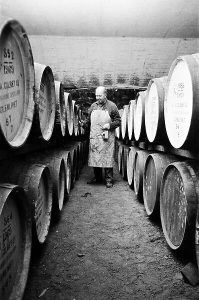 An employee of the Knockando Whisky Distillery checks the casks in the bonded warehouse