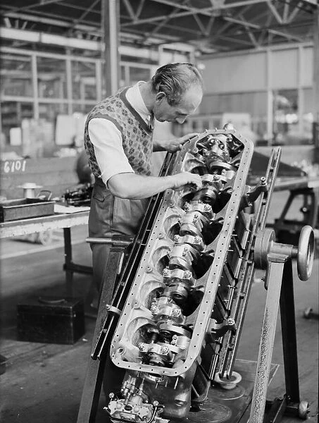 An engineer checks the pistons of the Gipsy Six engine during the construction of