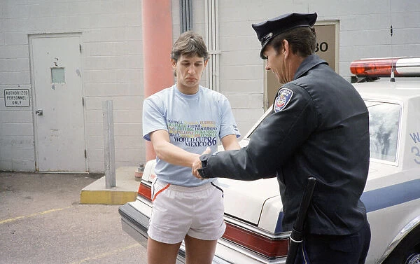 England football star Gary Lineker, is handcuffed by a police officer during a visit to a