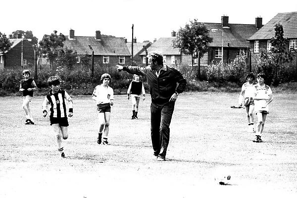 Former England footballer Bobby Moore coaches children at the Coral sponsored Bobby Moore