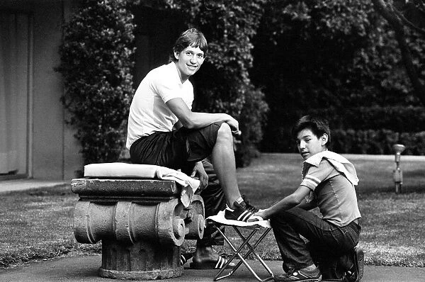 England footballer Gary Lineker has his boots cleaned by a shoe shine boy at the team
