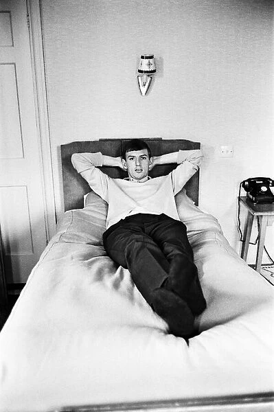 England footballer Martin Peters relaxes on the bed in his room at the team hotel in