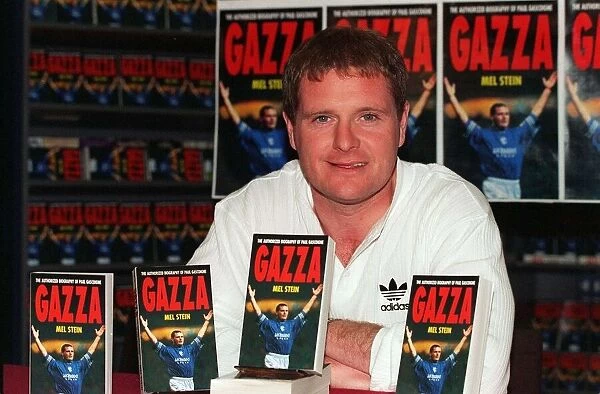 England footballer Paul Gascoigne holds up a copy of his latest autobiography at a book