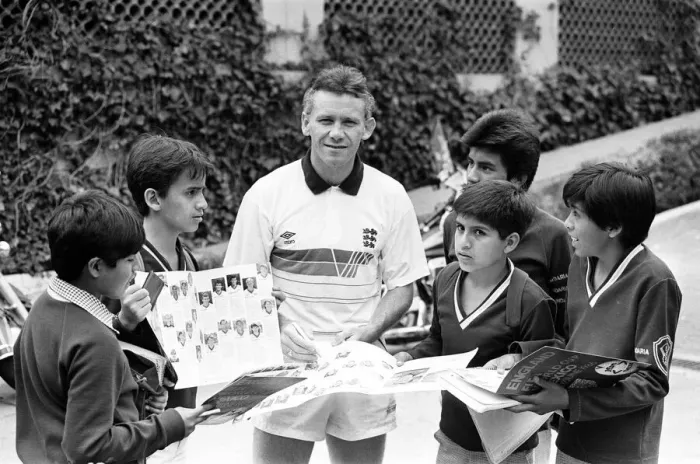 Framed Print : England footballer Peter Reid signs autographs for local children at the team base in