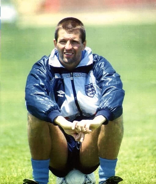 England footballer Steve Bull sitting on a football as he takes a break from training