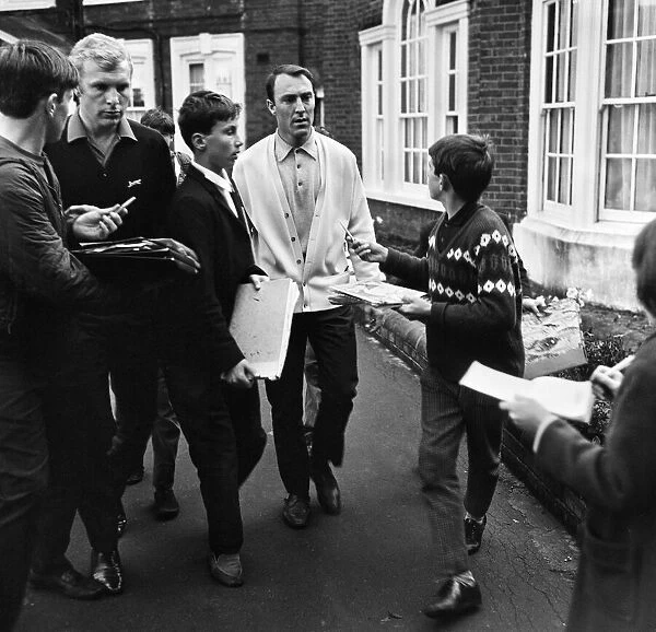 England footballers Bobby Moore and Jimmy Greaves are beseiged by young autograph hunters