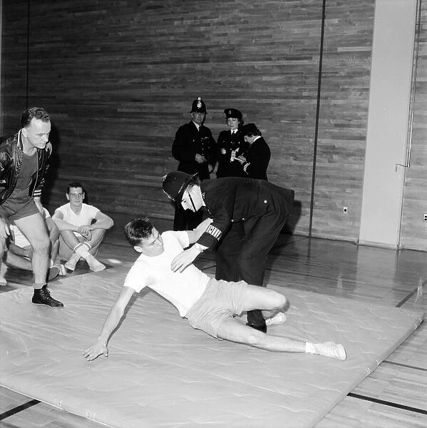 English police officers watch & take part in a hand to hand fighting training session at