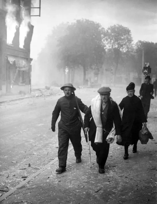 Framed Print : An English soldier helps some refugees through a burning town in Belgium following German Framed Print : An English soldier helps some refugees through a burning town in Belgium following German