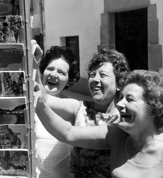 Three English women buy postcards in Tossa de Mar on the Costa Brava. 31st May 1965