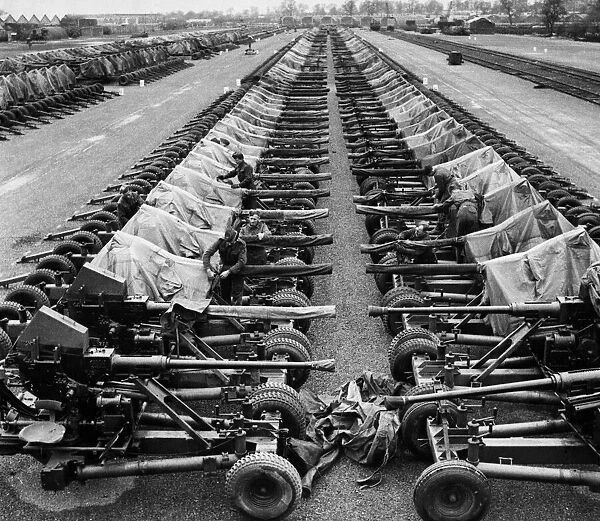 An equipment depot somewhere in England shows long lines of 40 m. m Bofors light A. A