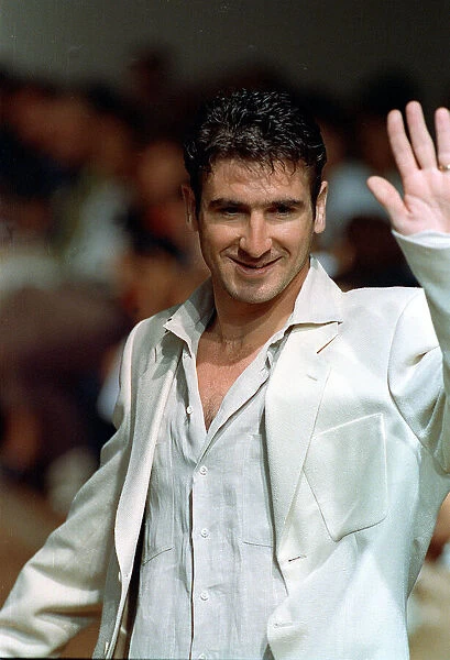 Eric Cantona models at Paco Rabanne show waving to public whilst on catwalk at the show
