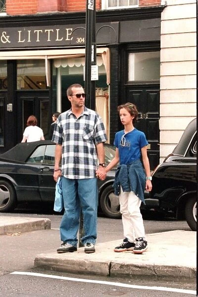 Eric Clapton musician and his daughter hold hands as they shop in the Kings Road London