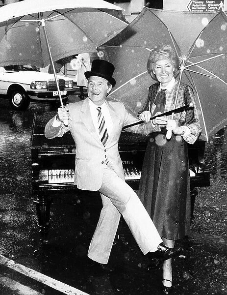Ernie Wise with his partner Erics wife Joan Morecambe dancing in the rain