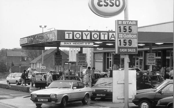 Esso Petrol Station with cars filling up and Ford Capri leaving. 2nd March 1986