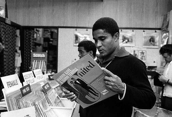 Eusebio, Benfica football player May 1968, looking at a Marvin Gaye record in a shop in