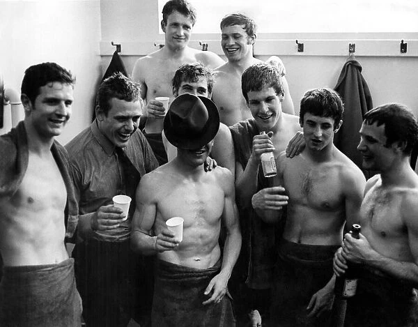 Everton hero, Johnny Morrisey, hides his face underneath his hat as the players celebrate