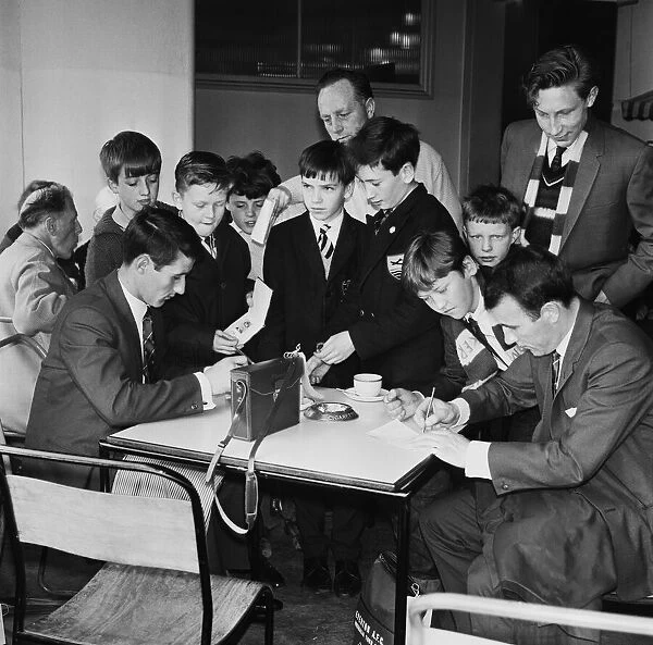 Everton players Derek Temple and Dennis Stevens sign autographs for young fans at Speke