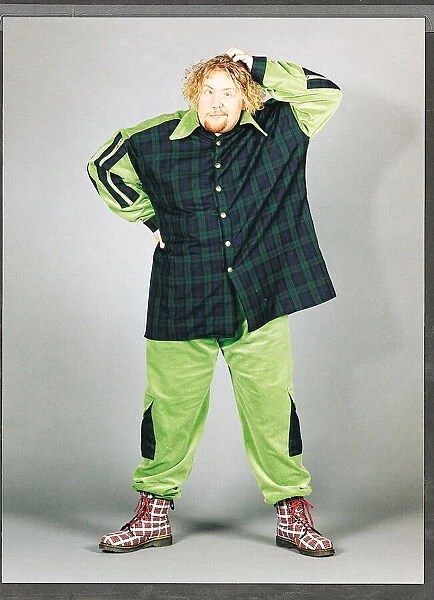 Ewan MacLeod in green and tartan suit scratching his head