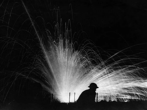 An exploding phosphorous round silhouettes a helmeted American soldier of the 28th