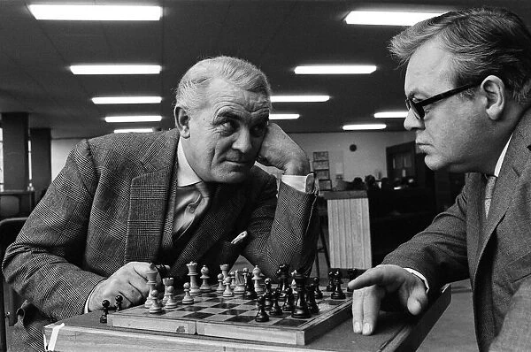 Eyeball to eyeball confrontation across the chess board for Clifford Evans, left