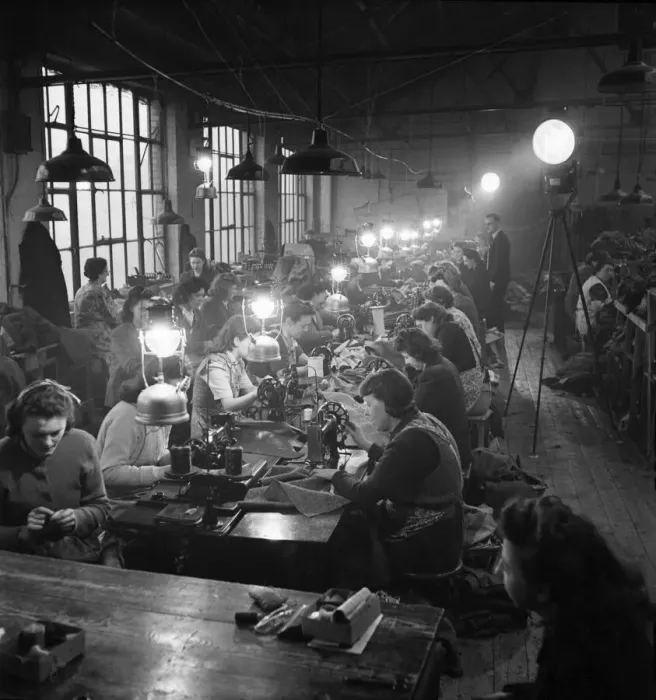 Framed Print : Factory girls at clothing works in East London use candle powered search lights for