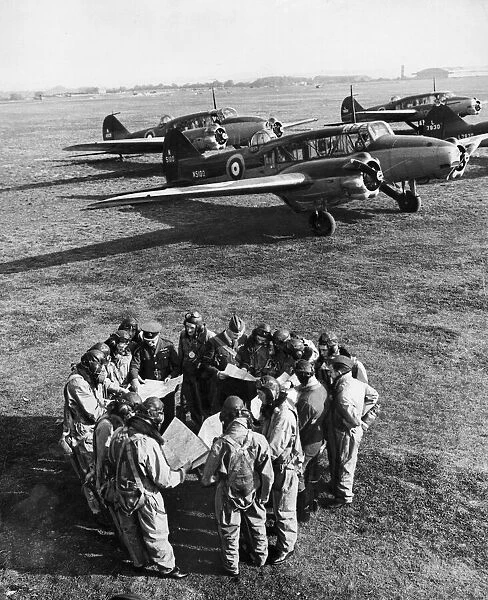 FAF pilots study maps and charts before taking a flight in an Avro Anson for their