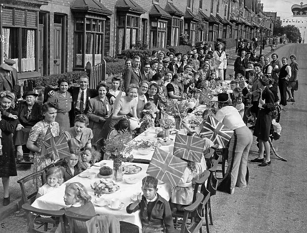 Families celebrate VJ Day in Heeley Road, Selly Oak with a street party. 15th August 1945