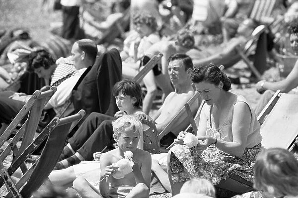 Families enjoying the summer sun and candy floss on the beach at Southend, Essex
