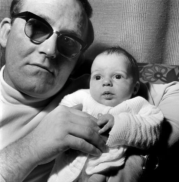 Families: Father holding his newly born baby boy at their home. December 1969 Z12116-001