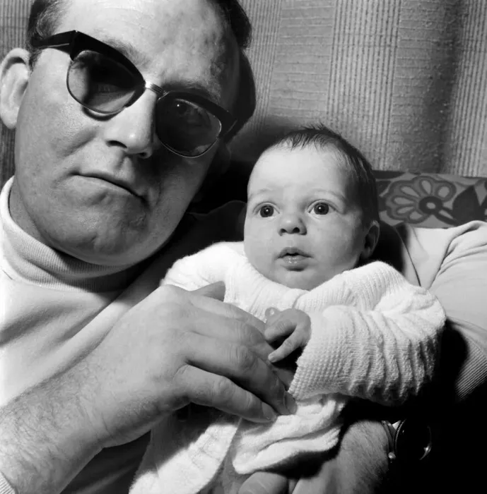 Framed Print : Families: Father holding his newly born baby boy at their home. December 1969 Z12116-001