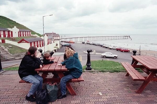 Families sitting on a bench looking at Saltburn pier, North Yorkshire. 9th May 1996