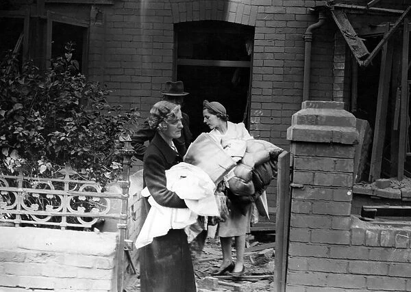 A family with their belongings after an air raid in a South Wales Town. Circa 1941