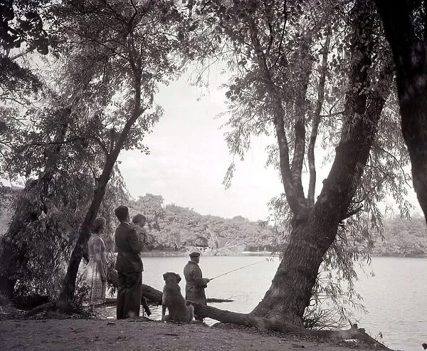 a family out in the countryside, fishing on the bank of a lake 1953 1950s day out