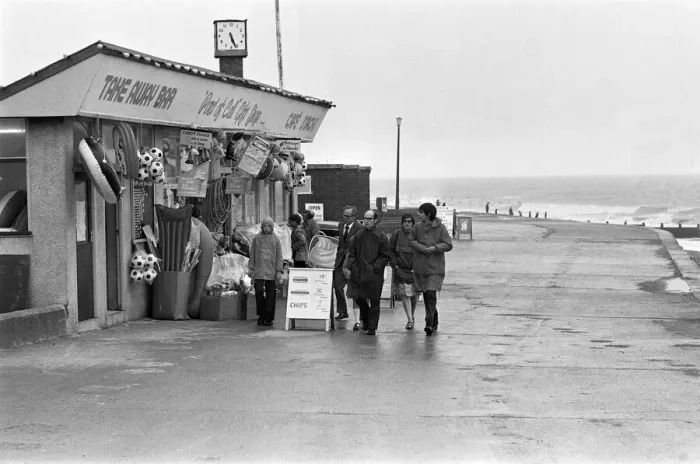 Framed Print : A family making the most of a walk on Hornsea sea front despite the weather conditions Framed Print : A family making the most of a walk on Hornsea sea front despite the weather conditions