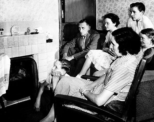 A family watch television together in their living room circa 1950