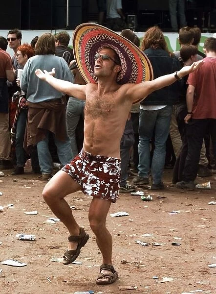 A fan does a dance at the Glastonbury Festival 1999 wearing sombrero