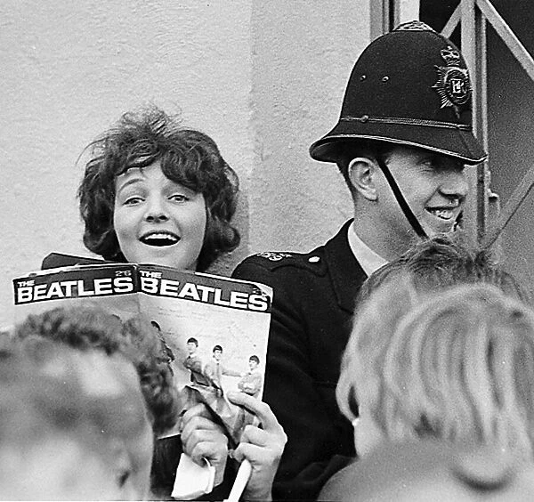 A fan holds a Beatles magazine in the crowd outside the Odeon Cinema, Cheltenham