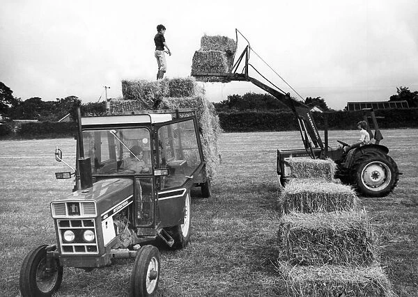 Farm hands at Blackwell Farm, near Carlisle lifting bales from the hayfield