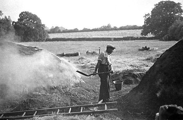 A farmer holding a shovel on a farm in England circa 1938