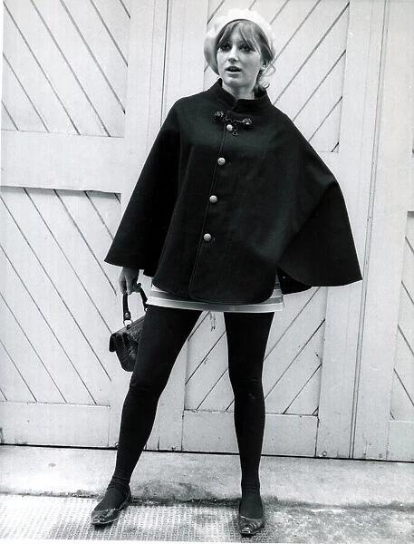 Fashion 1960s Model wearing a black cape, white beret