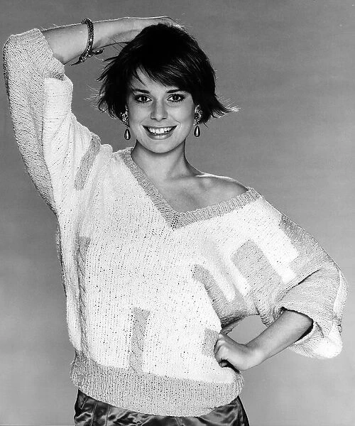Fashion Knitting February 1986 Model wearing V neck pullover posing with one hand