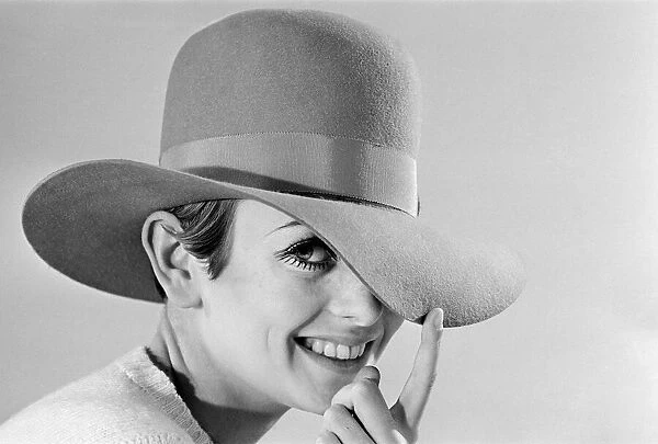 Fashion model Leslie Hornby, better known as Twiggy, modelling hats during a studio