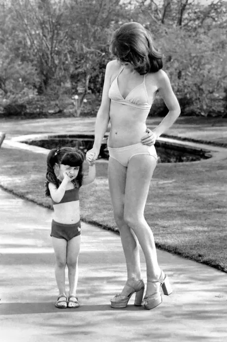 Framed Print : Fashion scene from Woolworth s. Woman wearing a bikini standing in the park with a Framed Print : Fashion scene from Woolworth s. Woman wearing a bikini standing in the park with a